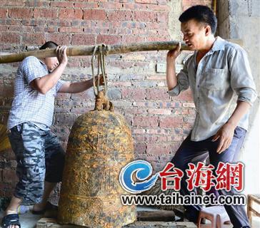 ▲古钟重达两百多斤,需两大汉才能扛起