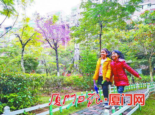 ▲雨后,小孩在花园式的小区内嬉戏玩耍。(本报记者 王火炎 摄)