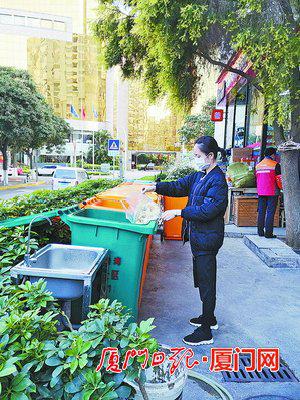 在江华社区财富港湾,居民把厨余垃圾倒入厨余垃圾桶。