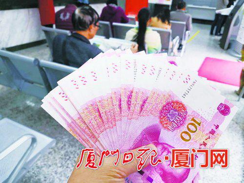 ▲前日,一位市民从银行取出崭新的钞票。