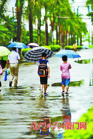 昨日上午,我市各地迎来明显降水,市民冒雨出行。(本报记者 张江毅 摄)