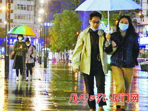 ▲昨日傍晚开始我市大部分地区出现降雨,图为市民撑伞遮雨。(本报记者 林铭鸿 摄)