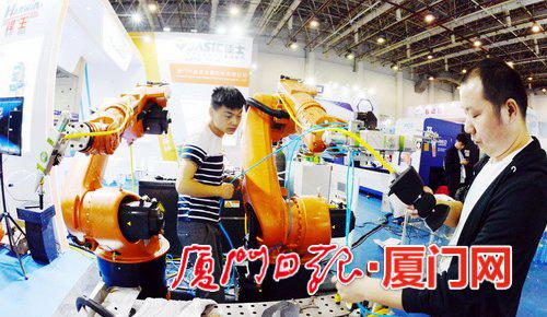 记者探营工博会布展现场,图为工作人员展示焊王工业机器人。