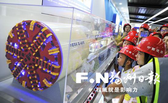 小朋友们在池边站智慧工地展厅内了解盾构机工作原理。