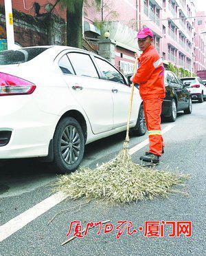 陈绍辉在清扫马路。(本报记者薛尧摄)