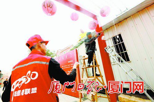 志愿者在现场帮忙布置展台。(本报记者何炳进摄)