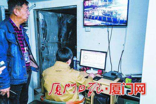 苏炳贤(右)在控制室内操作音乐喷泉播放设备。 (本报记者林铭鸿摄)