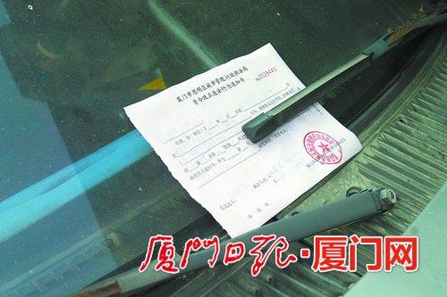 ▲联合整治前,城管执法部门对乱停放的车辆开具责令改正通知书。