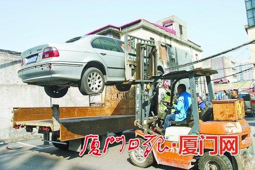 在群鸿商业城,联合整治队伍正在拖移“霸道”的“僵尸车”。