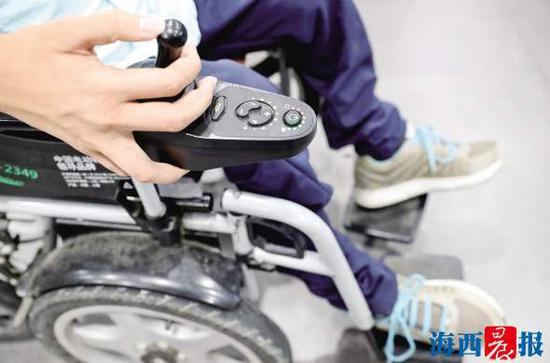 江溢洲用右手控制着电动轮椅,完成学业。记者 唐光峰 摄