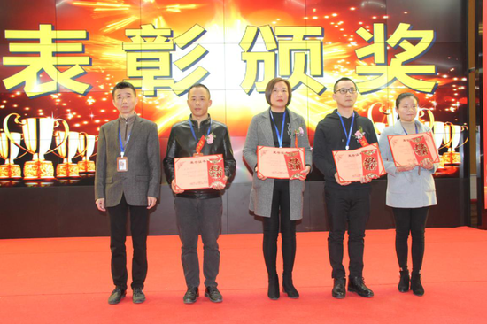△长富公司财务总监刘建东（左）给荣获2020年度优秀员工称号的员工颁奖
