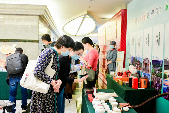 活动现场嘉宾驻足观赏三明特色产品