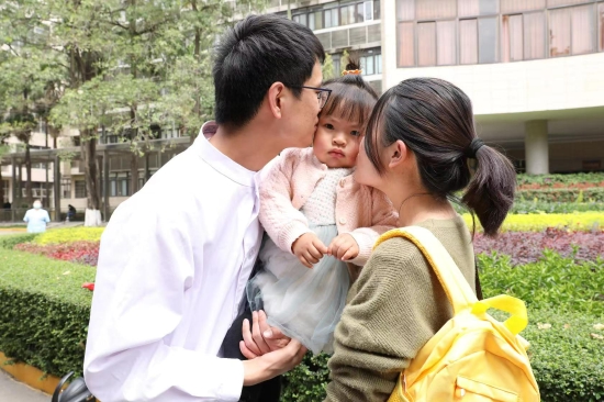 出征仪式上，中共党员儿科NICU护师林志杰与女儿告别。同为护士的爱人抱着一周九个月的女儿来给他送行。