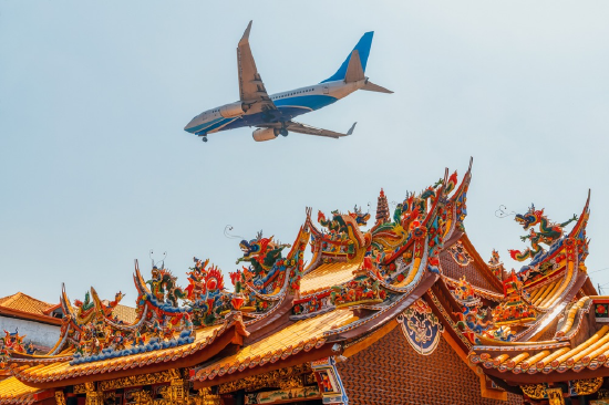厦门航空一架客机从厦门市清水宫寺庙上空飞过,厦门正在建设全新的国际机场。 视觉中国 图
