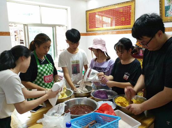 学生与村民叶雪梅为美食馆开展准备食材