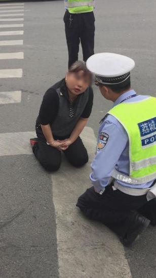 女子闯红灯遇查跪地交警陪跪 威胁交警后躺平