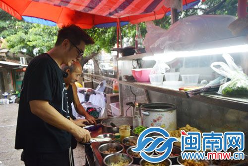 在摊前,陈浩民挑选菜品。