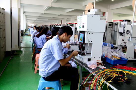 图为富顺光电充电桩生产车间内,工人正在装配产品 企业供图