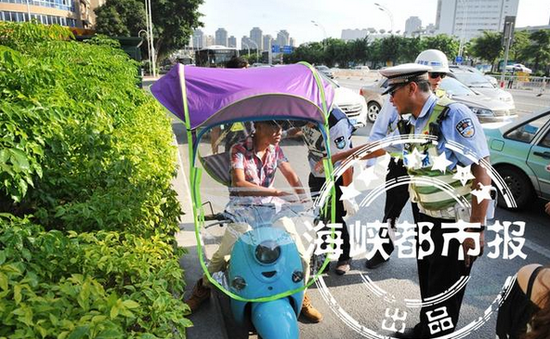 违规装伞的电动车被交警拦下