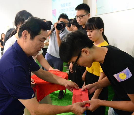 市慈善总会会长杨金兴与海翼集团纪委书记、工会主席邱曙平为贫困大学生代表颁发助学金