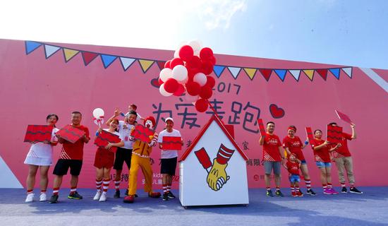 图为麦当劳福建高级总经理严平(左六)与麦当劳叔叔和爱心家庭代表一起为麦当劳叔叔之家“添砖加瓦”