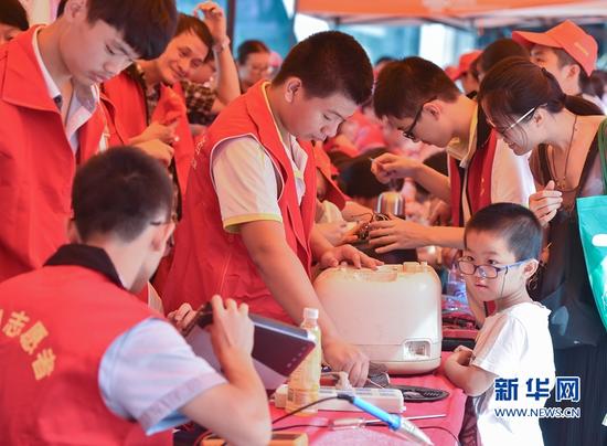 9月24日,福州机电工程职业技术学校的学生志愿者在为市民免费维修家电。
