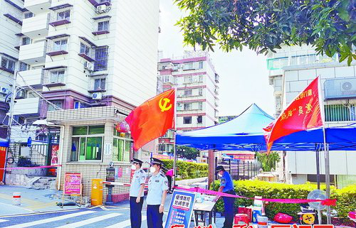 城管中队执法人员和派出所民警正在小区门口执勤。（湖里街道 供图）