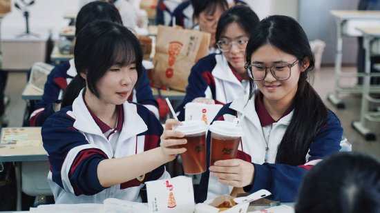 [图注：学生们享受必胜客美食]