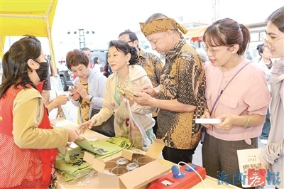 ▼侨胞和市民朋友手持消费券逛侨文化展摊位。