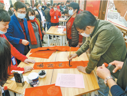 湖里街道举办“以爱敲门 请您留厦”活动,书法家挥毫泼墨为居民写春联送祝福。(湖里街道 供图)