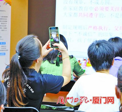 家长在主题讲座上认真记录。