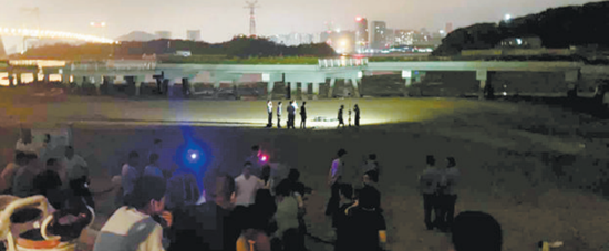 ■男子遗体被打捞上岸,民警正在勘查死因。
