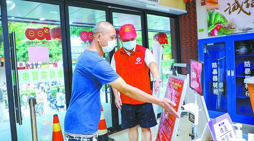 金尚农贸市场里，志愿者引导市民伸手测体温。(厦门日报记者 张奇辉 摄)
