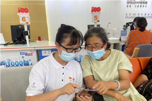 贵州联通六盘水分公司员工在帮助老年用户使用手机