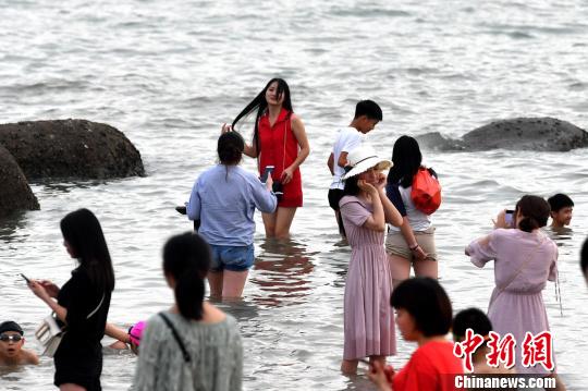 游客在厦大海滩拍照留念。吕明摄