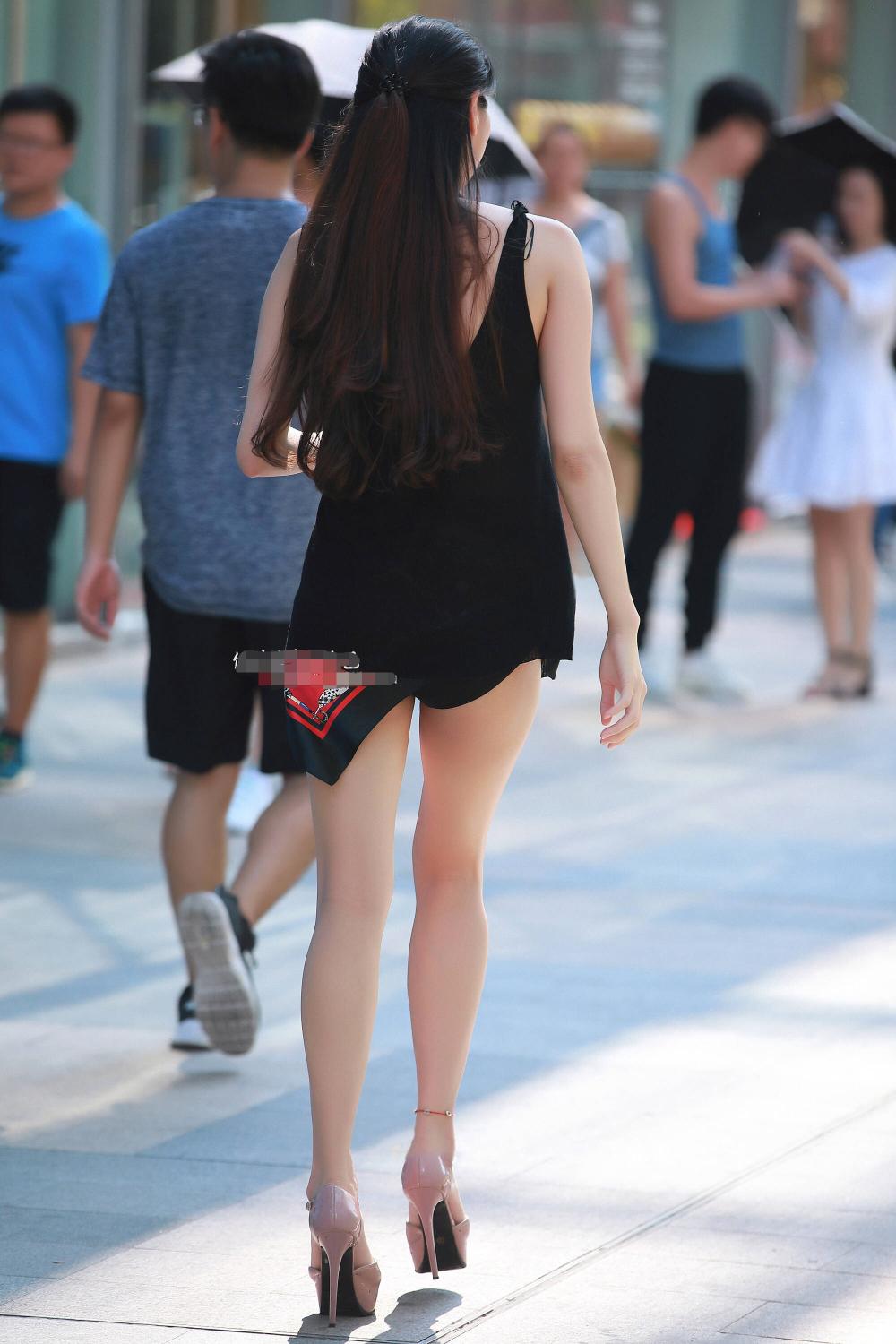黑色吊带裙超短裤的美女出门逛街,这美女有点混血的味道,不仅身材高挑