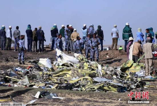 当地时间3月11日,在埃塞俄比亚首都亚的斯亚贝巴附近,救援人员在坠机现场清理飞机残骸。