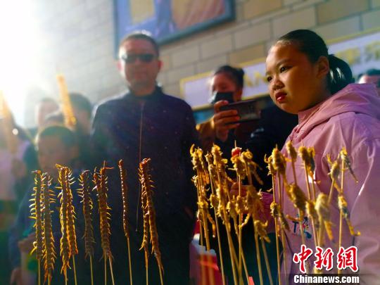 油炸蝎子美食展位吸引围观者。　王小军 摄