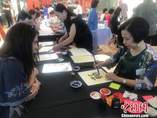 澳大利亚书法协会会长吴晓云(右)为观众书写“福”字。 陶社兰 摄