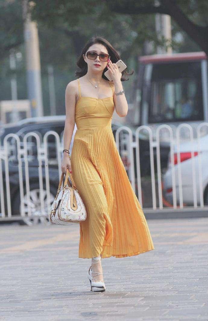 街拍:非常显眼的黄色吊带连衣裙美女，身材高挑，气质优雅!