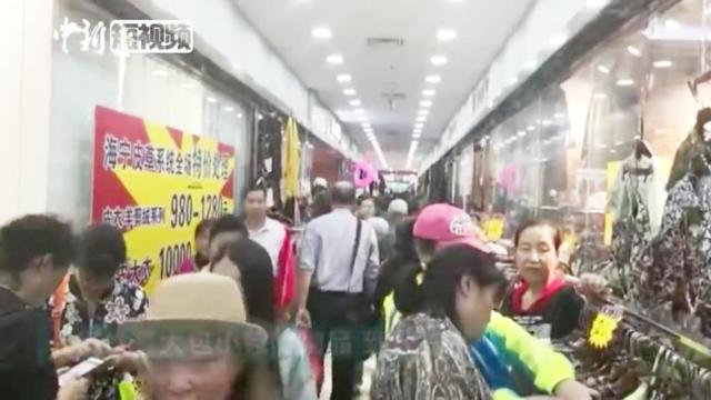 美国商场打折引华人代购疯狂扫货:在衣服堆上