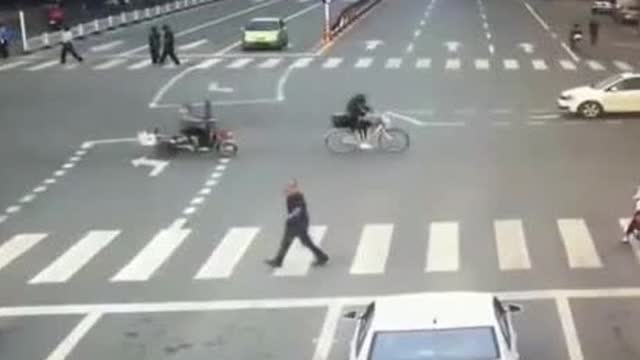 电动车无视交警闯红灯，惨遭小轿车猛烈撞击，监控拍下这惨烈一幕