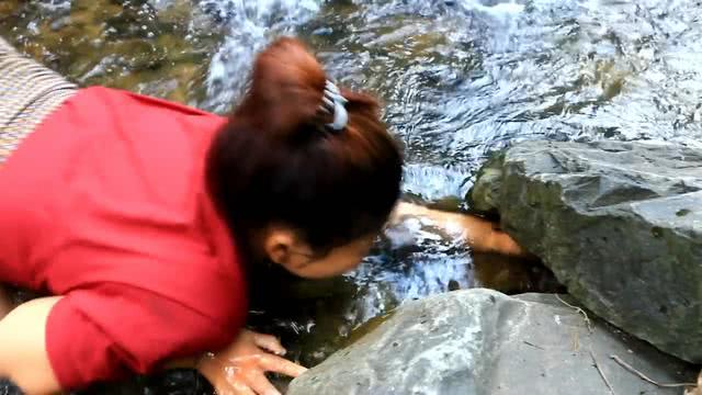 美女河边洗脸,看到石头底下一物在动,跑过去举起双手乐得跳起来
