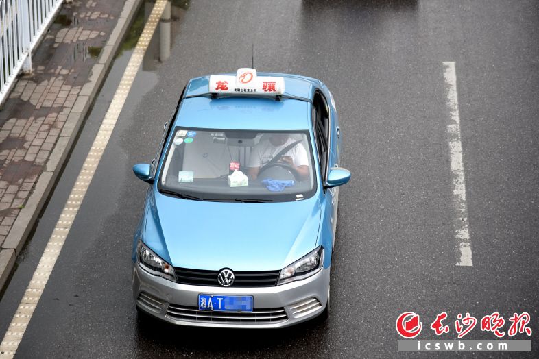 昨日下午3时左右,一辆出租车经过东二环长沙海关附近时,驾驶员一边抽烟、玩手机,一边驾车。长沙晚报记者 刘琦 摄