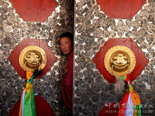 康坞大寺的大殿大门,一个僧人正好奇的观看前来参加开光法会的游人(刘成摄) 康坞大寺的大殿大门,一个僧人正好奇的观看前来参加开光法会的游人(刘成摄)