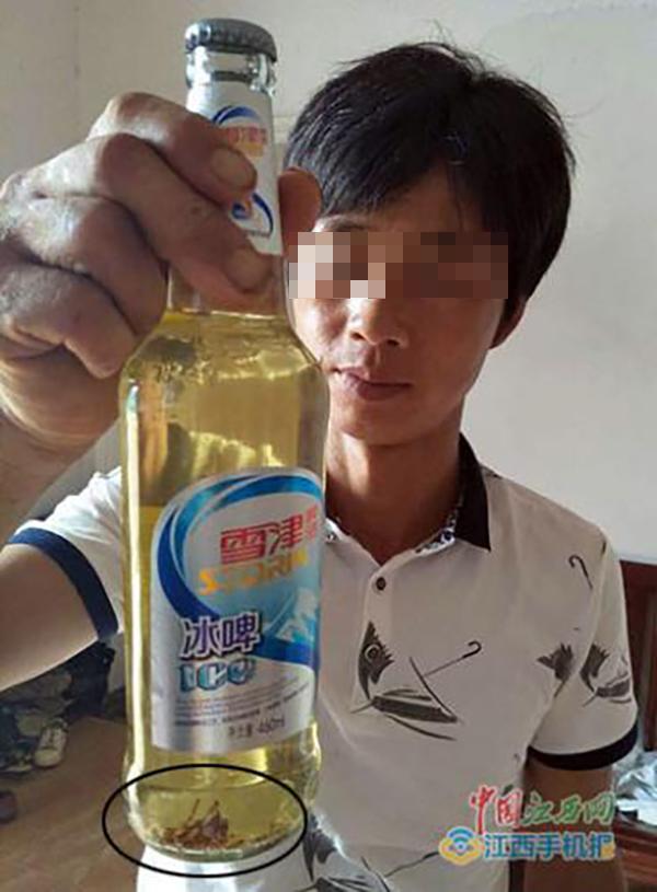 孙先生展示啤酒瓶中的虫体。中国江西网 图