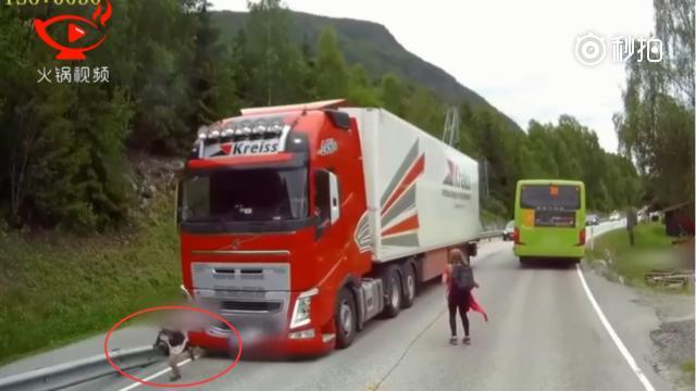 一名刚下公交车的小孩在横穿马路时，险些被迎面驶来的卡车撞到，拍摄的司机急...