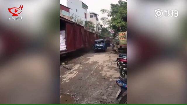 画面中，一辆蓝色的小卡车停放在一条单轨火车道旁边，远处正传来火车的鸣笛声...