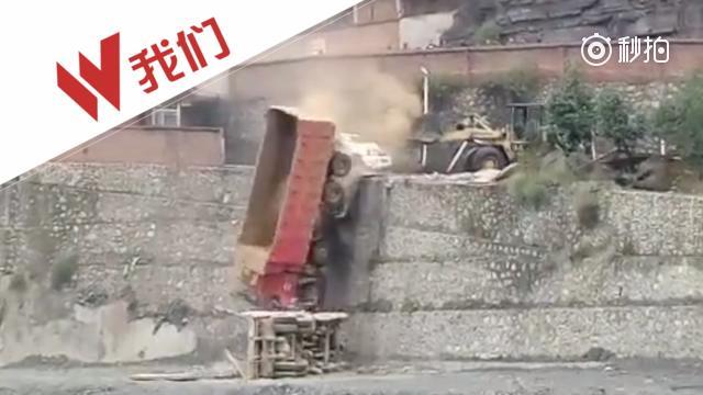 【因债务纠纷 铲车将小汽车大卡车推下近10米高台】