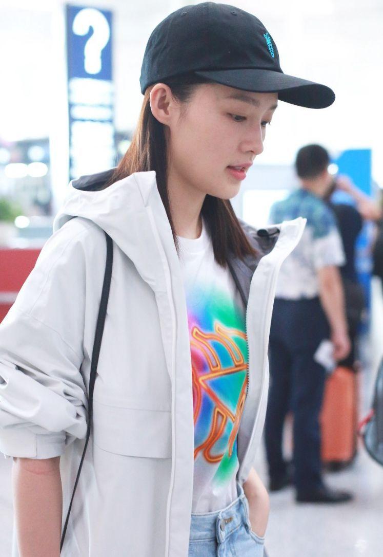 李沁穿白色风衣搭配蓝色牛仔短裙现身机场 酷酷中又带点小俏皮